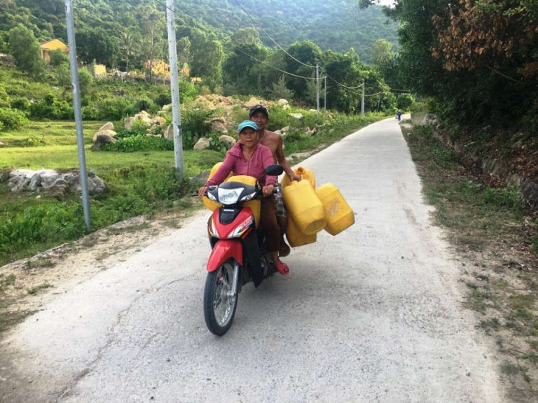Người dân xã đảo Tân Hiệp tranh thủ chạy xe máy lên khe suối để lấy nước